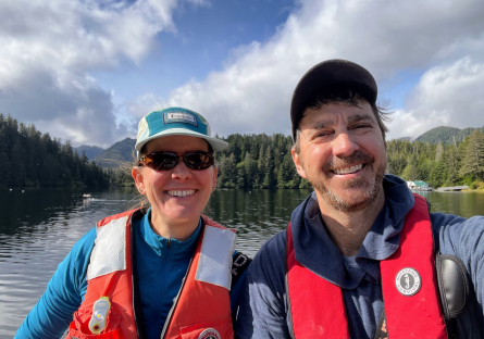 Professor and another participant posing in orange life vests.